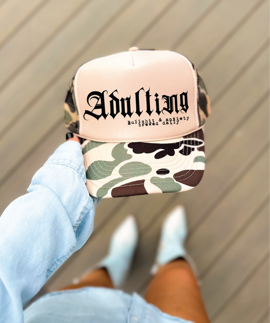 Adulting DTF Printed on A Duck Camo and Tan Trucker Hat